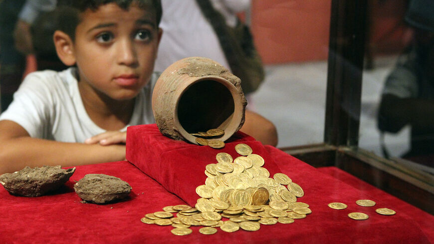 A boy looks at the coins displayed at the exhibition Coins through the Ages at the Egyptian Museum in Cairo, on Aug. 10, 2010.
