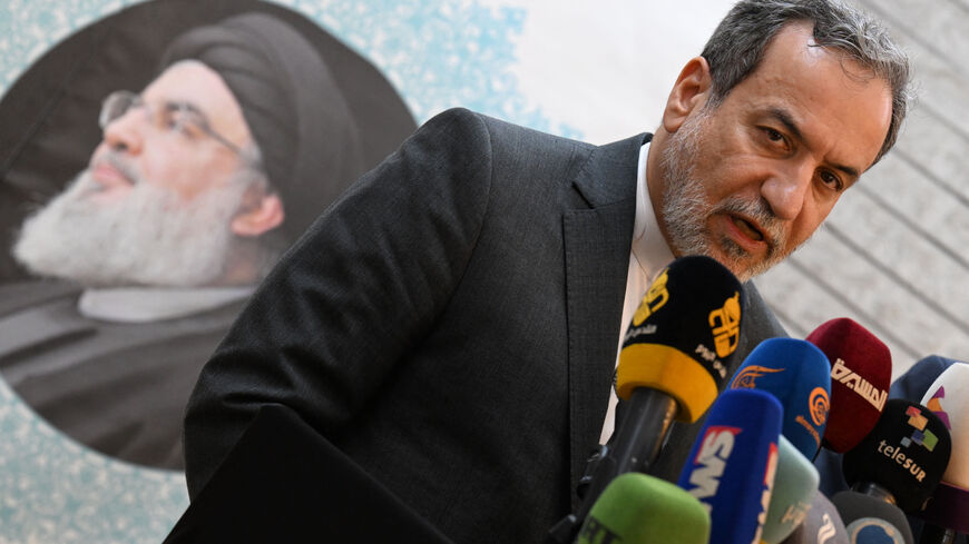 TOPSHOT - Iranian Foreign Minister Abbas Araghchi speaks to the press, in front of the portrait of slain Lebanese Hezbollah leader Hassan Nasrallah, after meeting with Syrian officials at the Iranian embassy in Damascus on October 5, 2024. (Photo by LOUAI BESHARA / AFP) (Photo by LOUAI BESHARA/AFP via Getty Images)