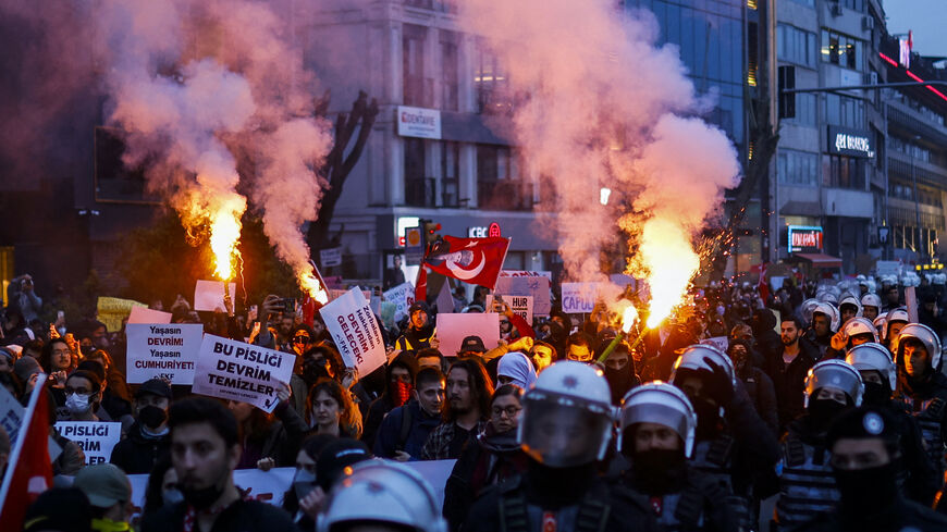 Escorted by riot police, students burn flares as they walk from the Besiktas district of Istanbul to Sarachane District and the Metropolitan Municipality City Hall building during a demonstration to support the city mayor, Turkey's President's main rival, four days after his arrest and detention as a result of a graft and terror probe, on March 24, 2025.