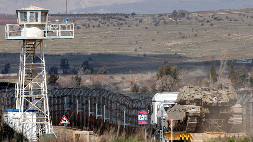 An Israeli army Merkava main battle tank is carried on the back of a trailer truck to be deployed near a watchtower of the UN-patrolled buffer zone's Quneitra checkpoint, separating Israeli and Syrian forces in the Golan Heights, on March 2, 2025. (Photo by Jalaa MAREY / AFP) (Photo by JALAA MAREY/AFP via Getty Images)