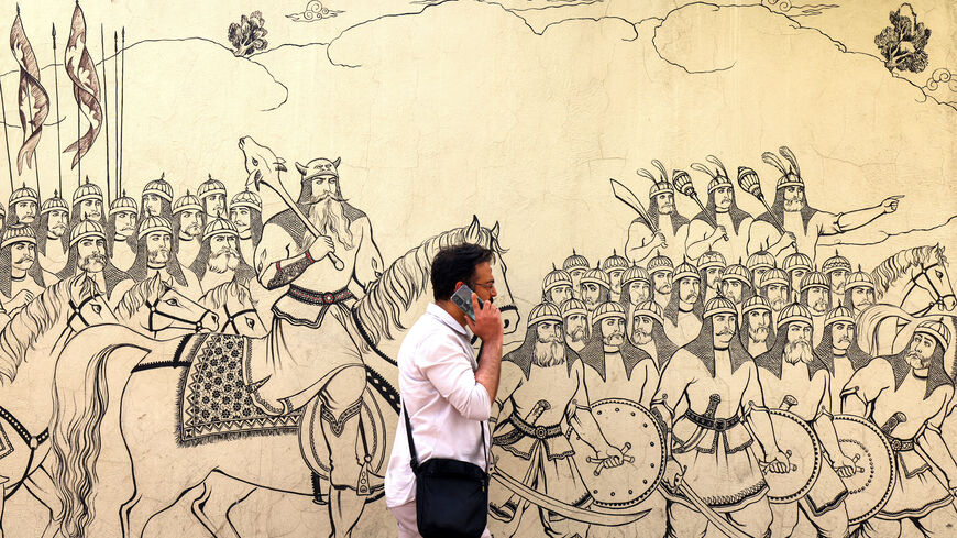 A man walks past a mural depicting a scene from the Iranian national epic "Shahnameh" in Tehran on April 8, 2025. Iran said on April 8 it will send its top diplomat to Oman for breakthrough talks with the United States, after President Donald Trump announced direct discussions on its nuclear programme. Iran ally Russia welcomed the prospect of negotiations for a new nuclear accord to replace the deal with major powers that was unilaterally abandoned by Trump in 2018. (Photo by ATTA KENARE / AFP) (Photo by A