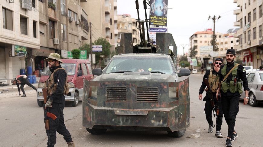 Members of Syria's security forces stand guard at a checkpoint in Ashrafiyat Sahnaya, near Damascus, after days of deadly sectarian clashes involving the Druze, May 1, 2025.