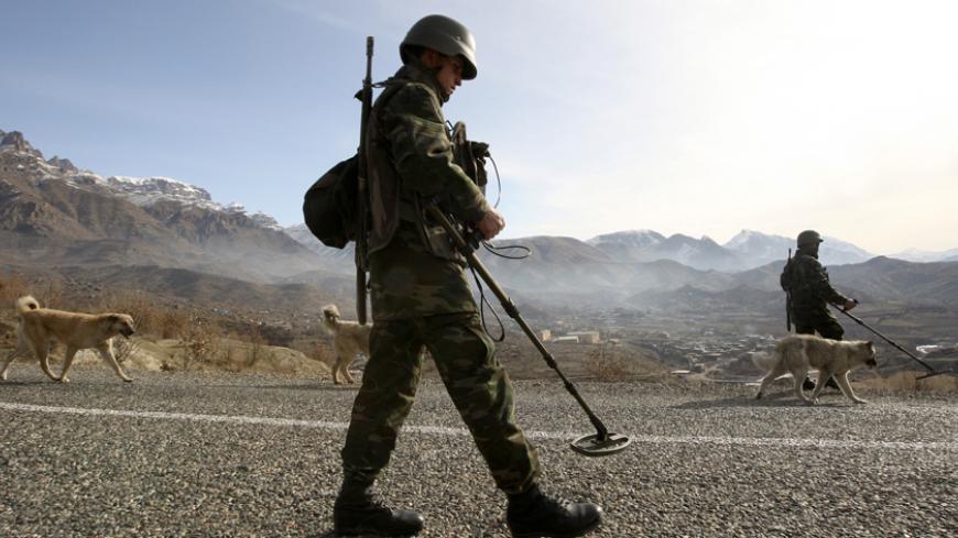 Turkish soldiers use mine detectors to search for landmines during a patrol on a road outside the south-eastern Turkish town of Sirnak bordering northern Iraq February 24, 2008. Turkey began sending thousands of ground troops across the mountainous border into northern Iraq on Thursday to crush PKK guerrillas who use the region as a base from which to attack targets inside Turkey. REUTERS/Fatih Saribas (TURKEY) - RTR1XHU0