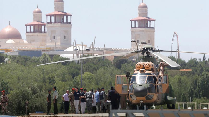 A security member, who was injured during an attack at a camp for Syrian refugees in eastern Jordan near the borders of Iraq, Syria and Jordan, is transported from a military helicopter to al-Hussein Medical Centre in Amman, Jordan, June 21, 2016.  REUTERS/Stringer - RTX2HCMY