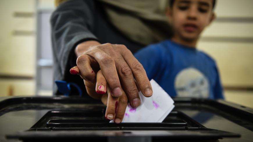 An man Egyptian casts his ballot with a child at a polling station during the third day of a referendum on constitutional amendments, at a school in shamma village in the northern Nile delta province of Menoufia, on April 22, 2019. (Photo by Mohamed el-Shahed / AFP)        (Photo credit should read MOHAMED EL-SHAHED/AFP/Getty Images)
