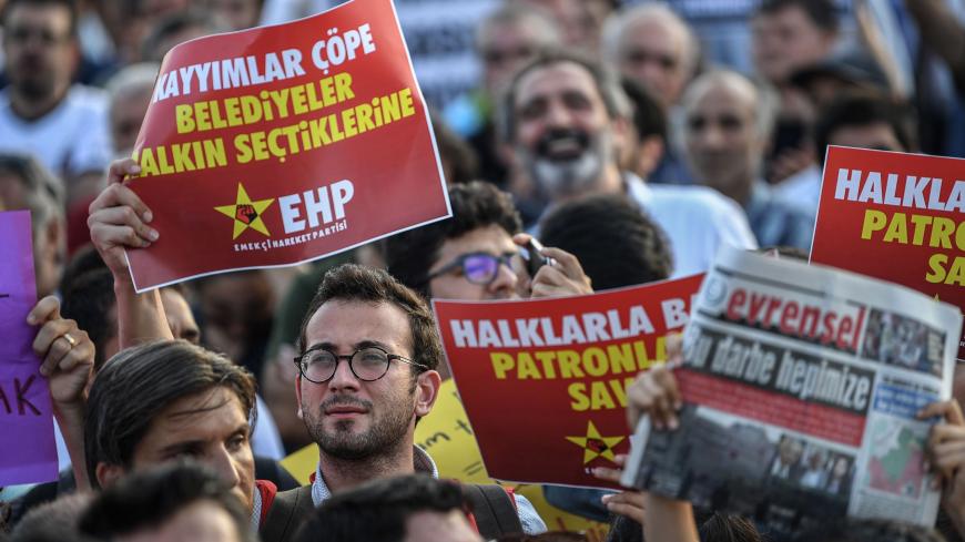 Demonstrators hold placards reading 'Replaced mayors to trash, give us back our elected mayors'  during a protest against the replacement of Kurdish mayors with state officials in three cities, at Kadikoy district in Istanbul, on August 23, 2019. - The Turkish government removed three mayors from office on Monday over alleged links to Kurdish militants as Ankara deepened its crackdown on the opposition.The mayors of Diyarbakir, Mardin and Van provinces in eastern Turkey -- all members of the pro-Kurdish Peo