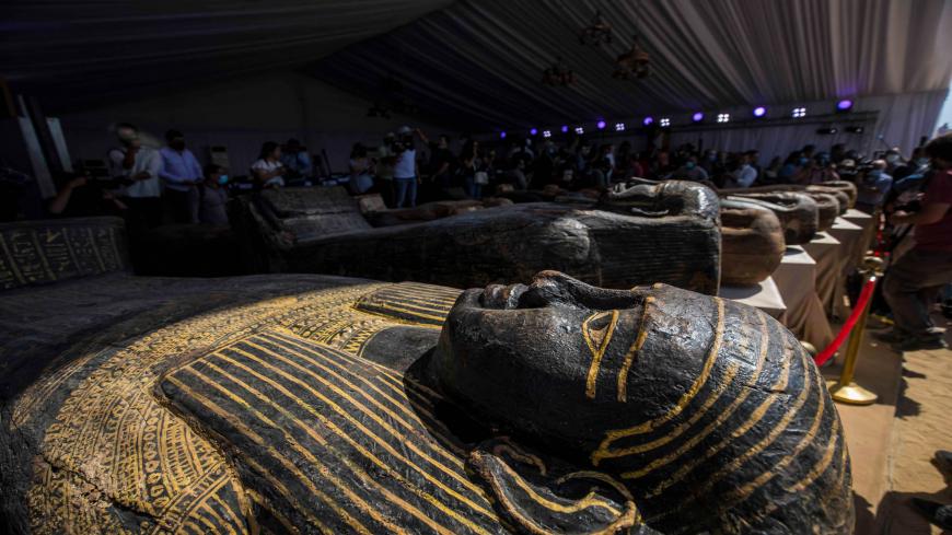 A picture taken on October 3, 2020 shows sarcophaguses, excavated by the Egyptian archaeological mission which discovered a deep burial well with more than 59 human coffins closed for more than 2,500 years, displayed during a press conference  at the Saqqara necropolis, 30 kms south of the Egyptian capital Cairo. - They were unearthed south of Cairo in the sprawling burial ground of Saqqara, the necropolis of the ancient Egyptian capital of Memphis, a UNESCO World Heritage site. Their exteriors are covered 