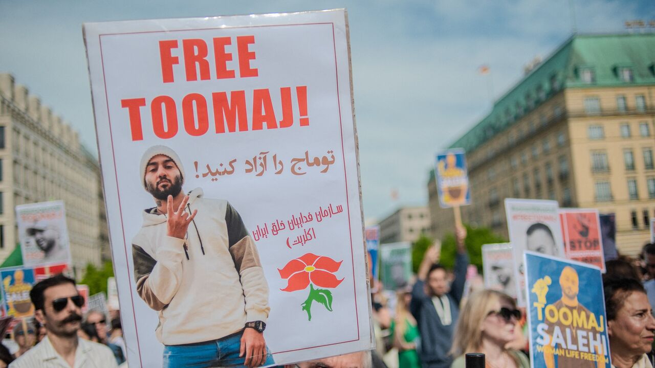 Protesters hold signs during a rally protesting against a death sentence given to Toomaj Salehi, a famous Iranian rapper, in Berlin, Germany, on April 28, 2024.