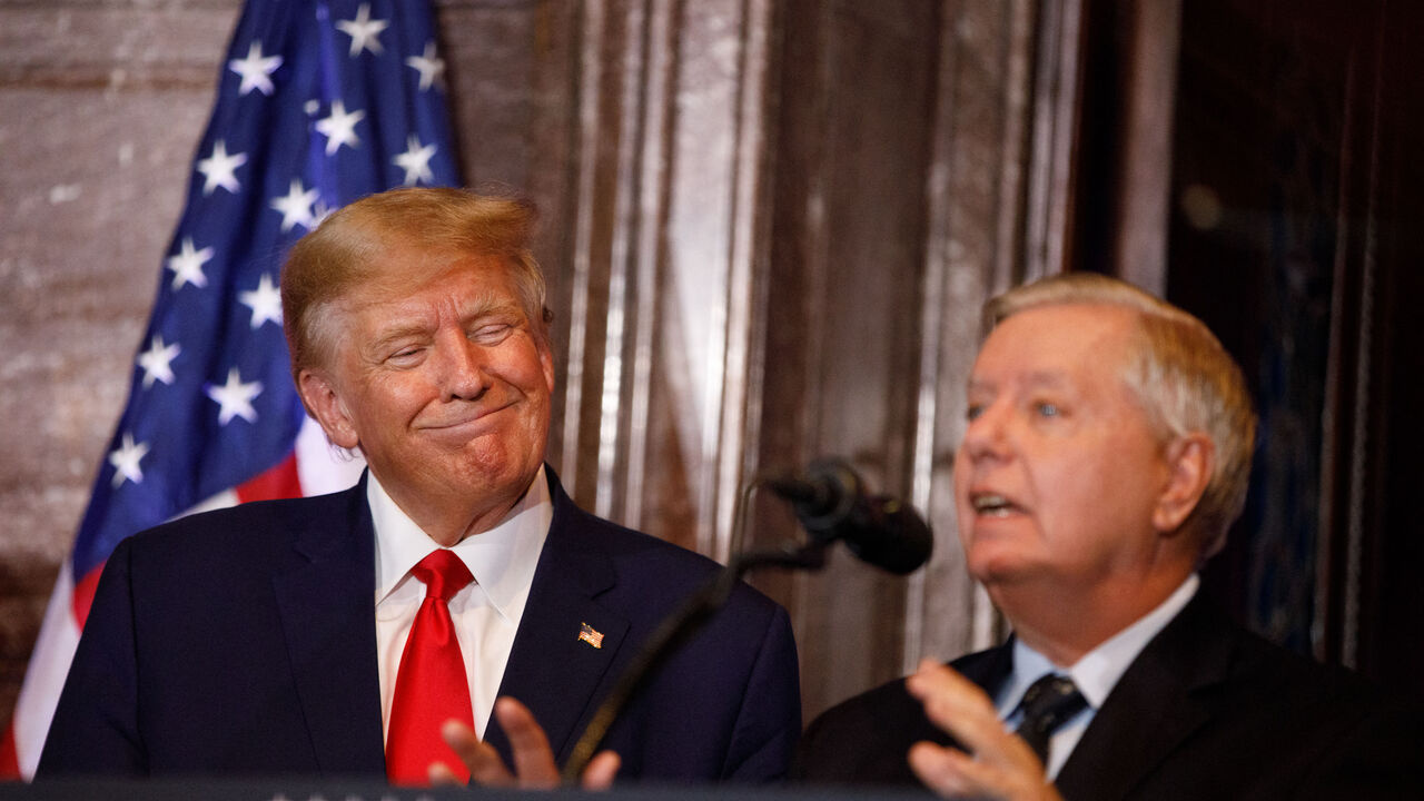 Former US President Donald Trump gestures as US Senator Lindsey Graham (R-SC) addresses the crowd during a 2024 election campaign event in Columbia, South Carolina, on January 28, 2023. Trump hits the campaign trail Saturday for the first time in a third bid for the US presidency overshadowed by intensifying criminal investigations and a firestorm of political controversy. The twice-impeached Republican, whose party lost the White House and both chambers of Congress during his term, makes his case for anoth