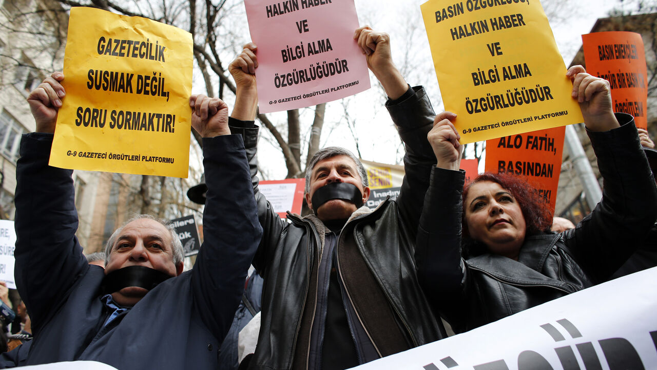 Journalists demanding freedom for the media take part in a protest against Turkey's ruling AK Party (AKP) in Ankara Journalists demanding freedom for the media take part in a protest against Turkey's ruling AK Party (AKP) in Ankara February 15, 2014. The signs read: "Journalism is asking questions, not keeping silent" (L) and "Press freedom also means people's freedom to access information" (C and R). REUTERS/Umit Bektas (TURKEY - Tags: POLITICS CIVIL UNREST MEDIA) - RTX18VGG