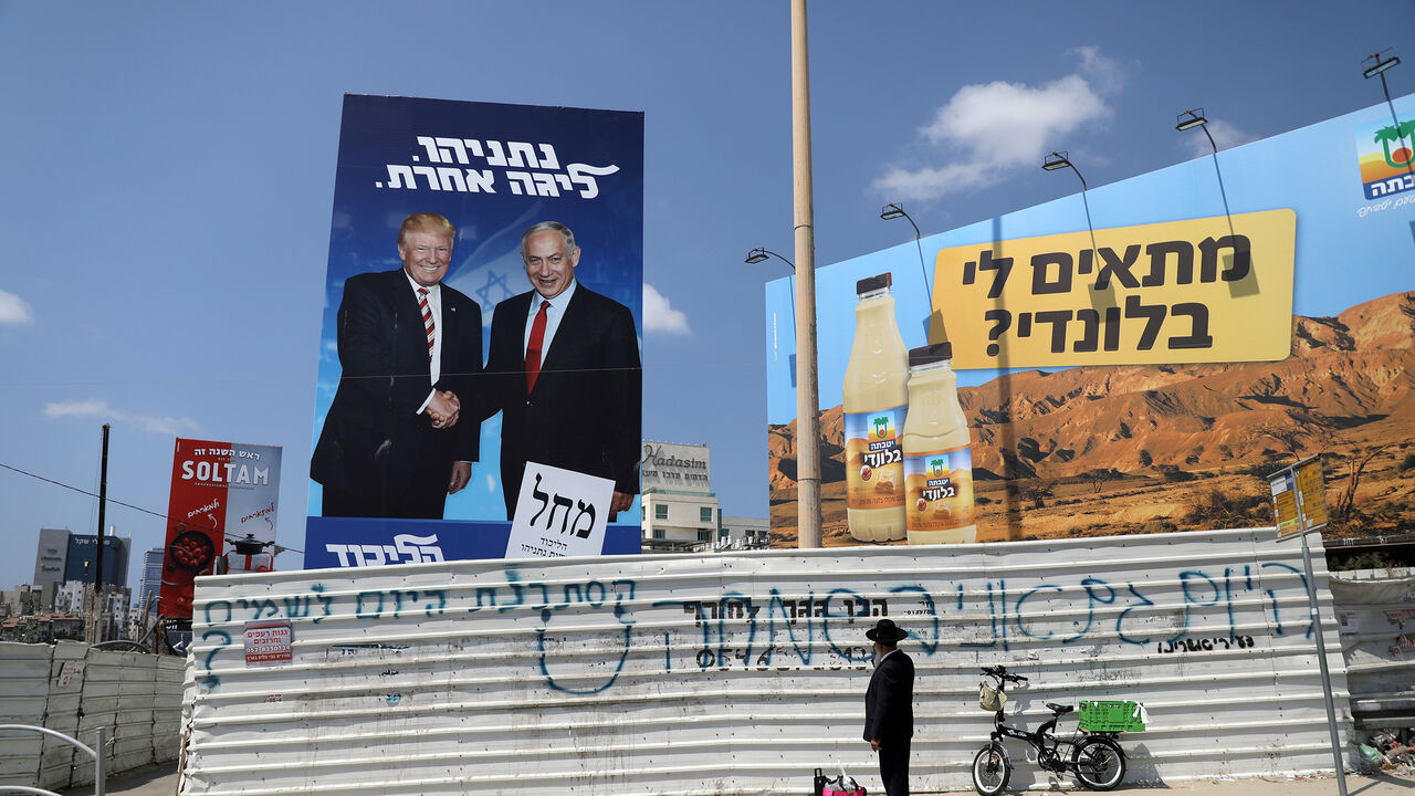 ISRAEL-ELECTION/ An ultra-Orthodox Jewish man stands next to a Likud party election campaign banner depicting Israeli Prime Minister Benjamin Netanyahu and U.S. President Donald Trump in Bnei Brak, Israel September 9, 2019. The words in Hebrew read, "Netanyahu, a different league" REUTERS/Ammar Awad - RC1F7BD95F00