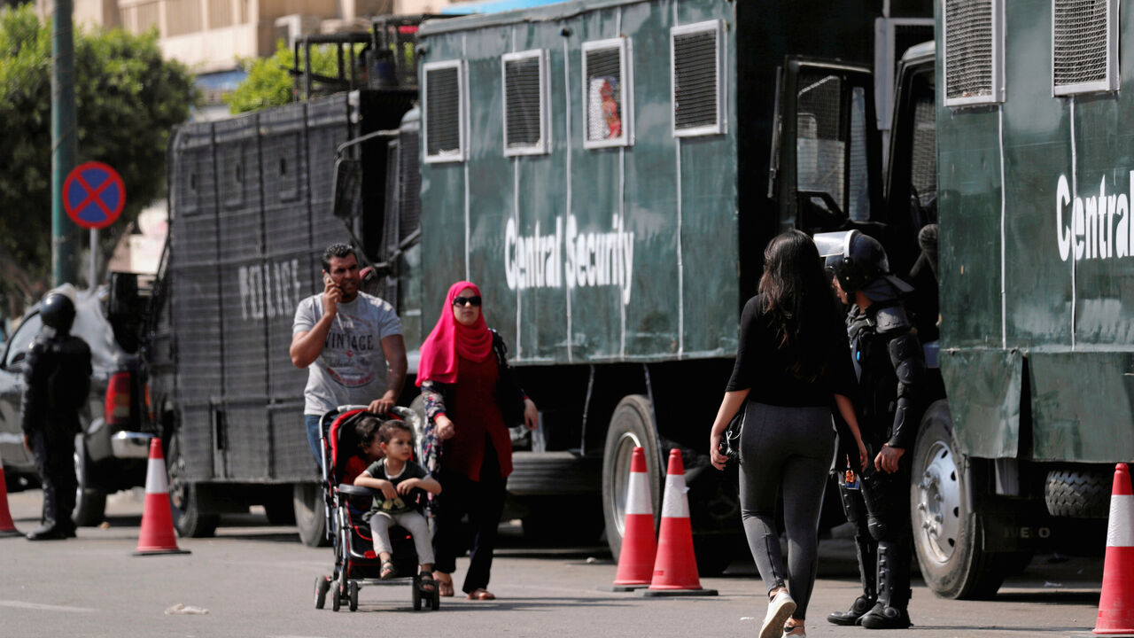 People walk in front of Egyptian riot police are seen on Tahrir square on the road to U.S. Embassy in Cairo, Egypt May 14, 2018. REUTERS/Amr Abdallah Dalsh - RC12866621B0