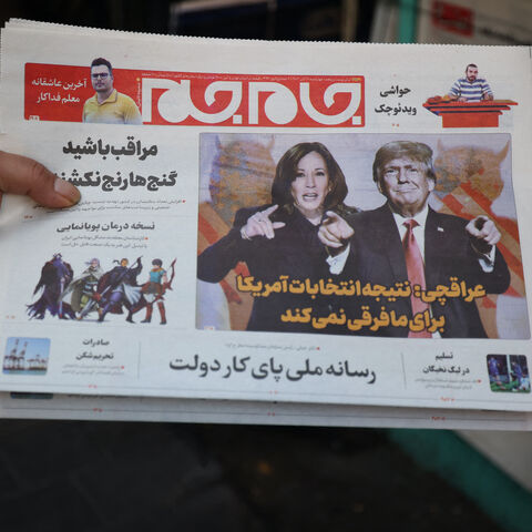 An Iranian holds a local newspapers with frontpage news on the US presidential vote outside a kiost in Tehran on Nov. 6, 2024.